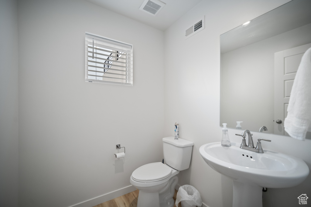 Bathroom featuring sink, hardwood / wood-style floors, and toilet