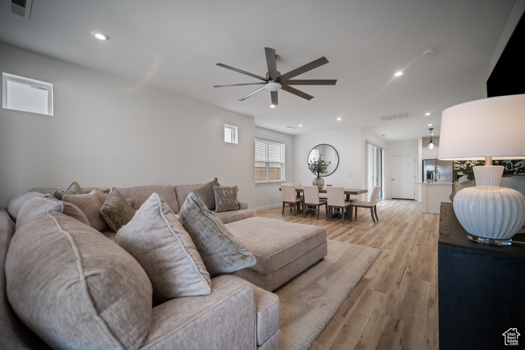 Living room featuring ceiling fan and light hardwood / wood-style flooring