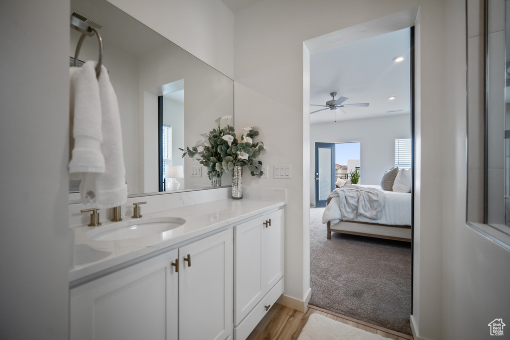 Bathroom with hardwood / wood-style floors, vanity, and ceiling fan