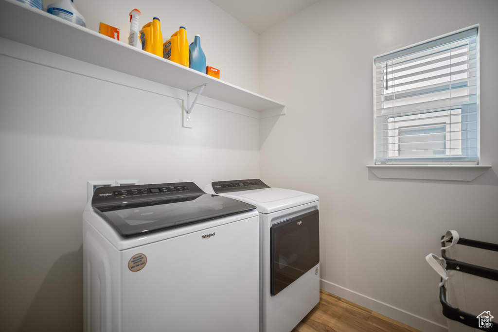 Laundry area featuring independent washer and dryer and hardwood / wood-style floors