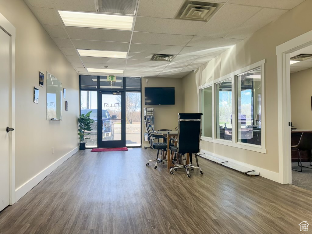 Office with a paneled ceiling, a healthy amount of sunlight, and dark wood-type flooring