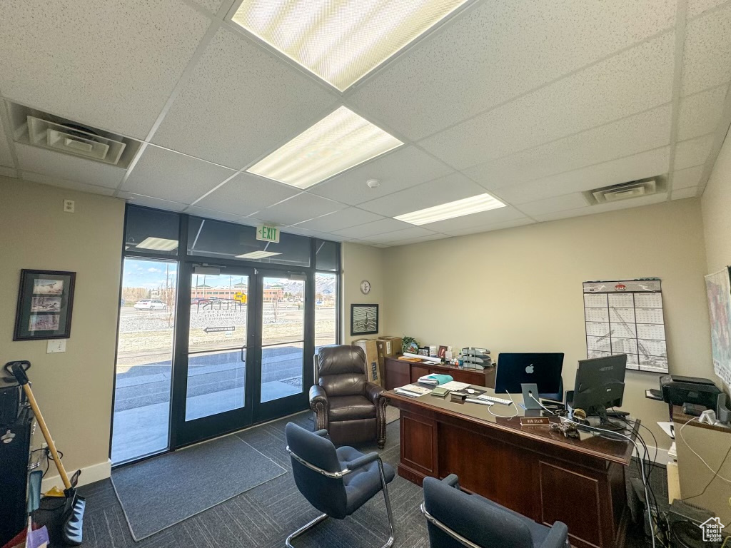 Carpeted office space featuring french doors and a drop ceiling