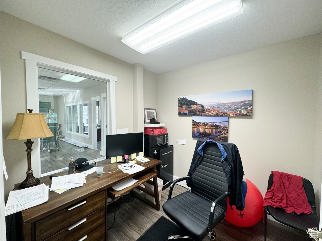 Office area with wood-type flooring and a textured ceiling