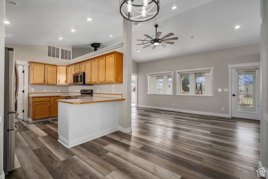 Kitchen featuring high vaulted ceiling, ceiling fan with notable chandelier, dark hardwood / wood-style floors, and stainless steel appliances