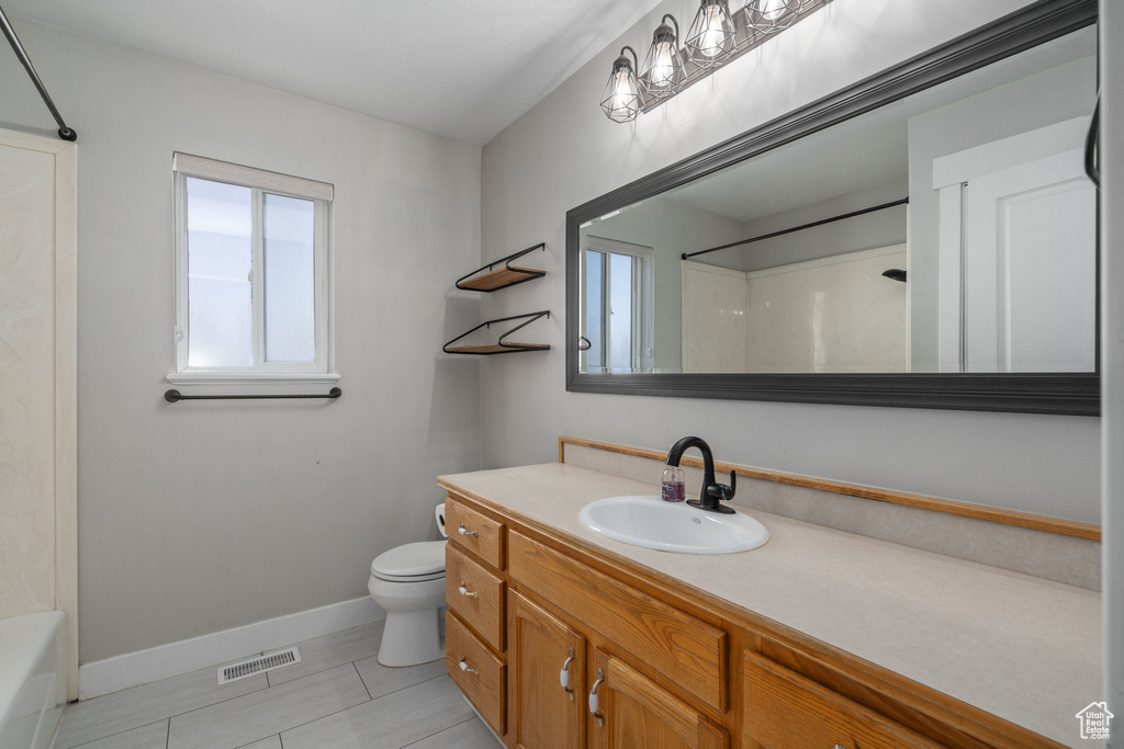 Full bathroom featuring shower / washtub combination, toilet, large vanity, and tile floors