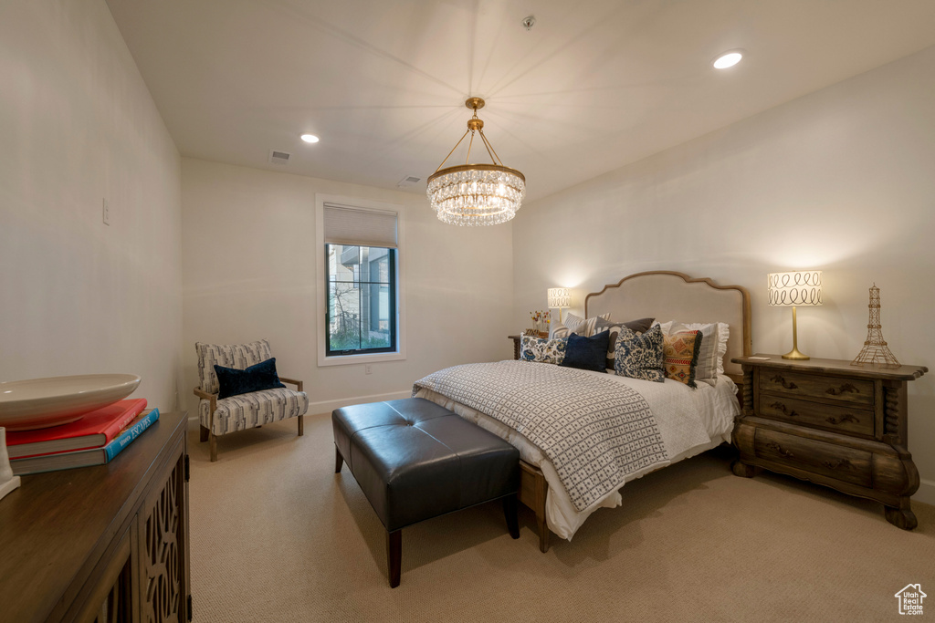 Carpeted bedroom featuring a notable chandelier