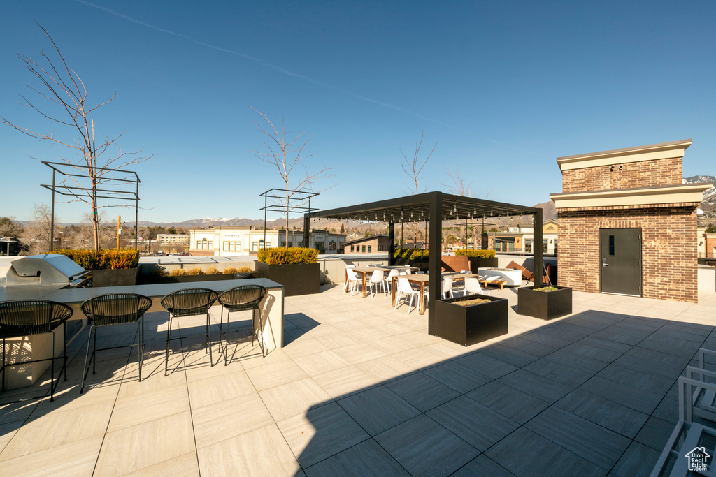 View of patio with exterior bar and an outdoor kitchen
