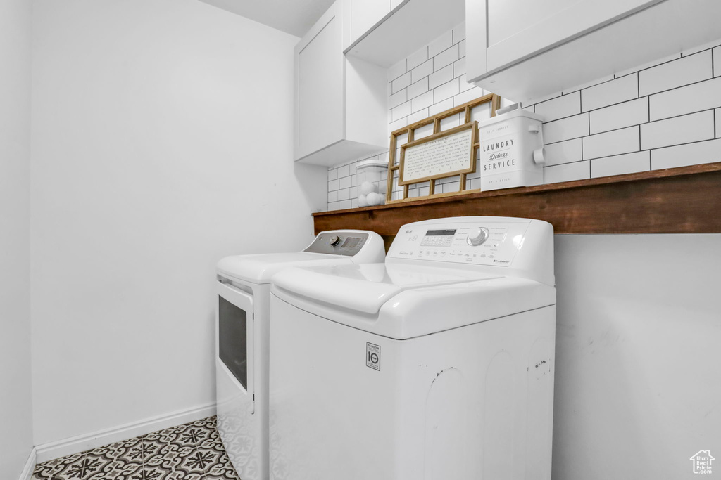 Clothes washing area featuring separate washer and dryer and tile flooring