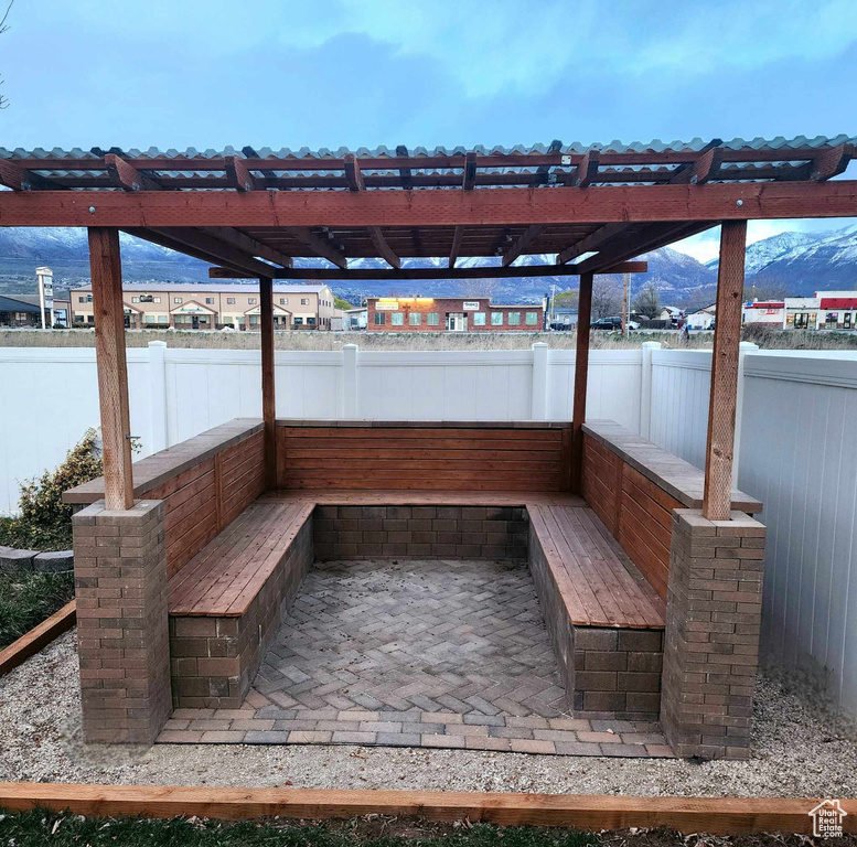 View of dock featuring a mountain view, a patio area, and a pergola
