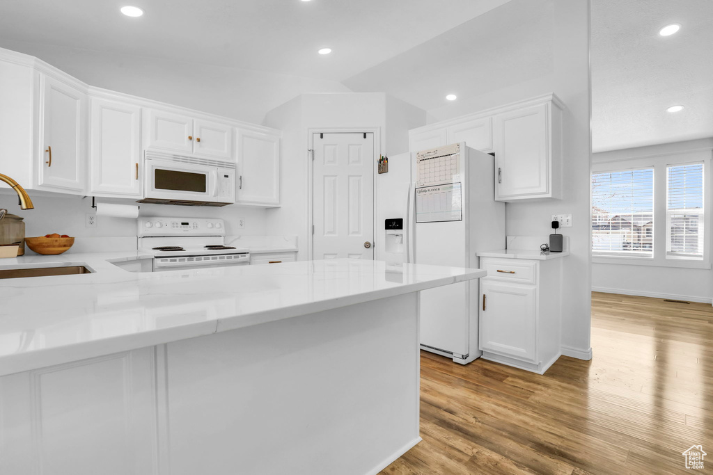 Kitchen featuring sink, light wood-type flooring, white appliances, and white cabinetry