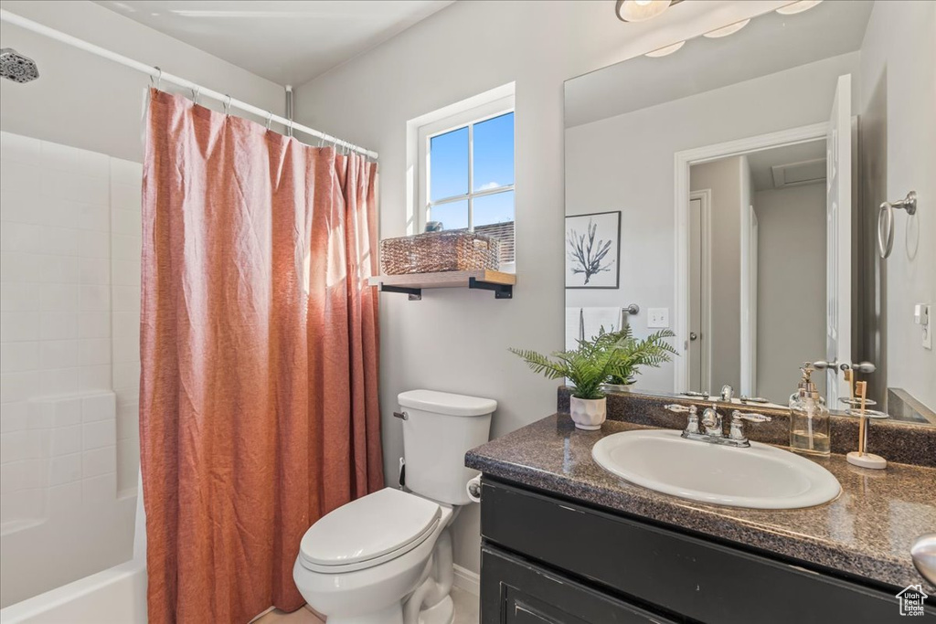 Full bathroom featuring shower / tub combo with curtain, toilet, and oversized vanity