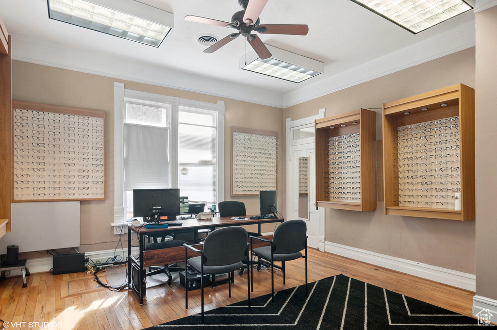 Office area with ornamental molding, light wood-type flooring, and ceiling fan