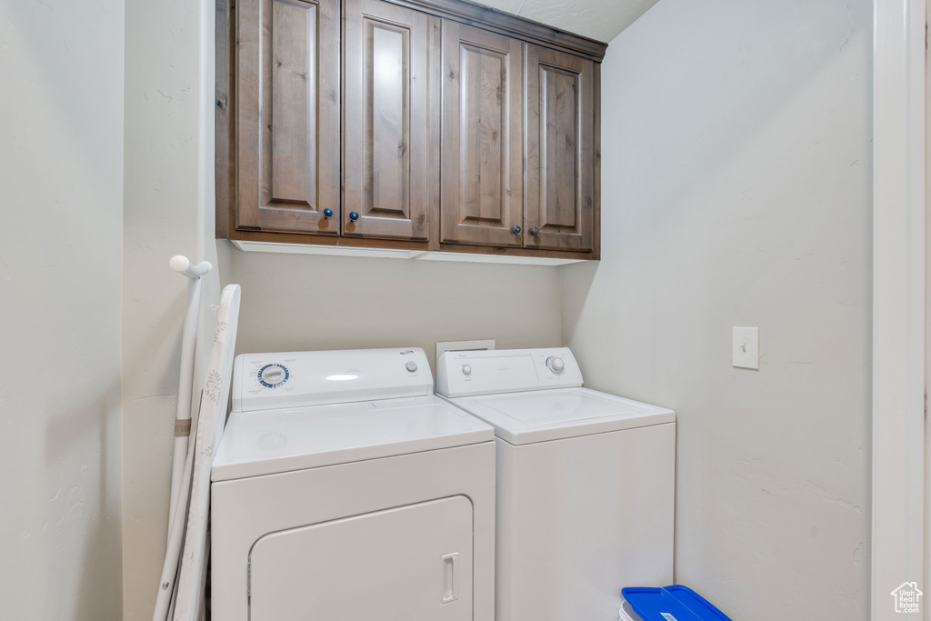 Laundry room featuring cabinets and washer and dryer