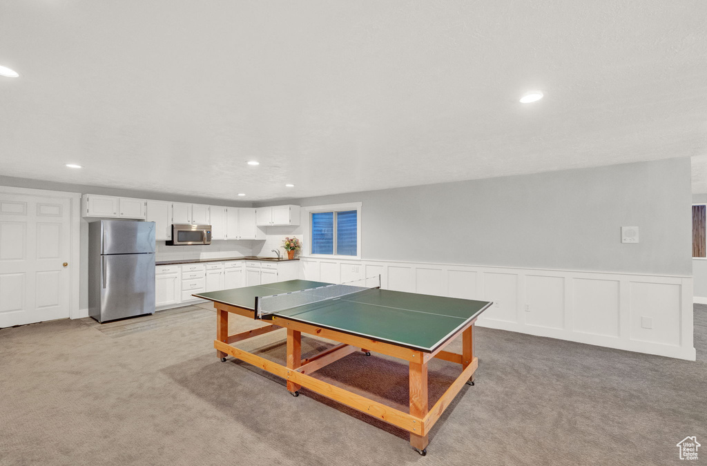 Game room with light carpet and sink