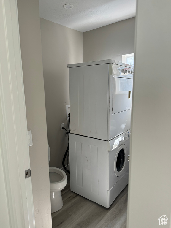 Laundry area with light wood-type flooring and stacked washer / drying machine