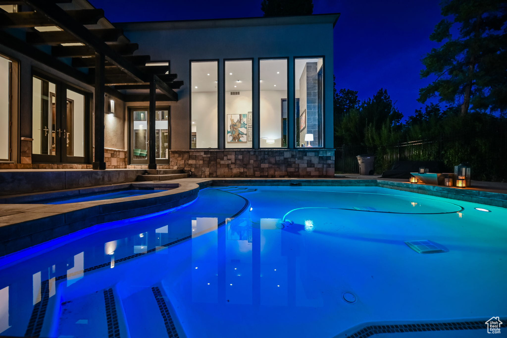 Pool at night with french doors