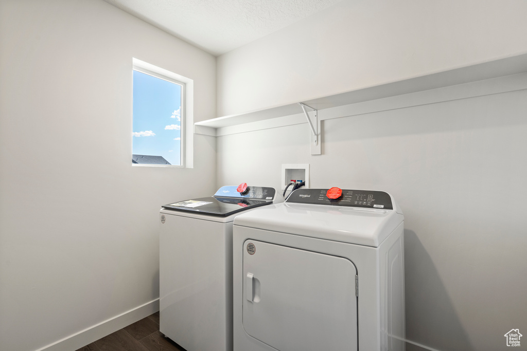 Laundry room featuring dark hardwood / wood-style floors, washer hookup, and washing machine and clothes dryer