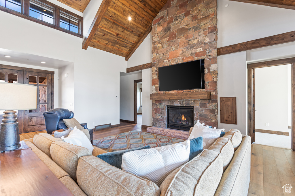 Living room featuring a fireplace, dark hardwood / wood-style flooring, wooden ceiling, and high vaulted ceiling