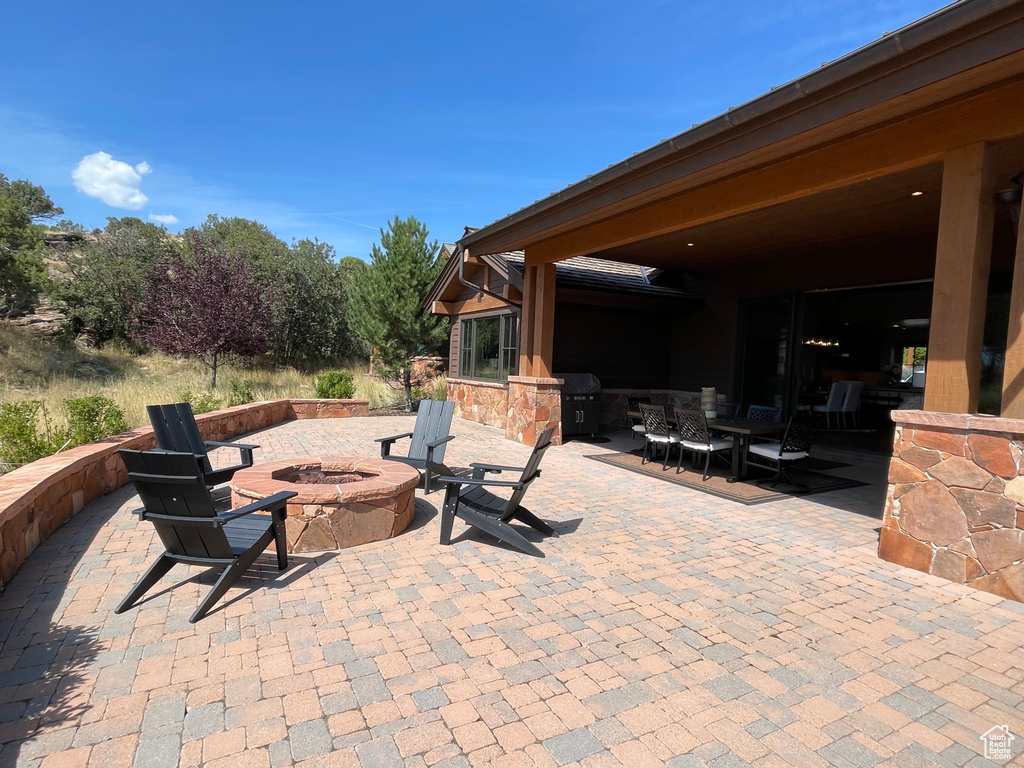 View of patio featuring an outdoor fire pit and area for grilling