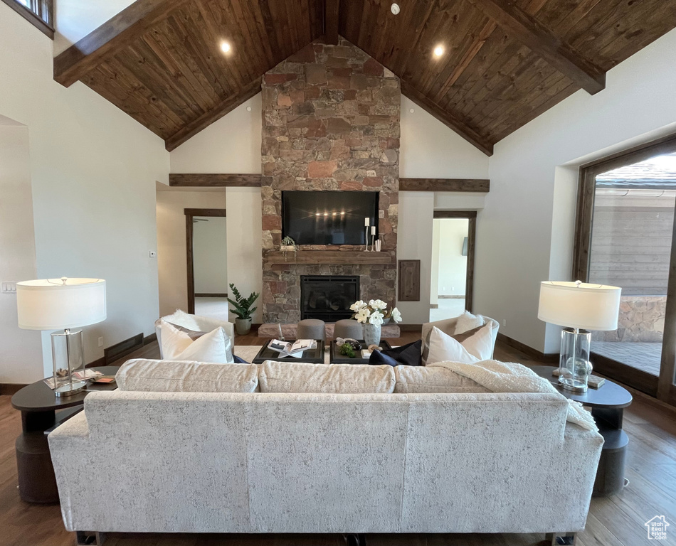 Living room featuring a fireplace, high vaulted ceiling, hardwood / wood-style floors, and wooden ceiling