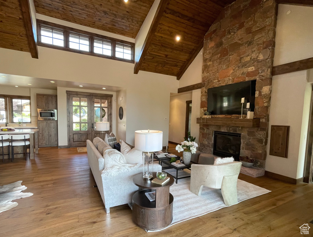 Living room featuring wood ceiling, high vaulted ceiling, hardwood / wood-style flooring, and a fireplace