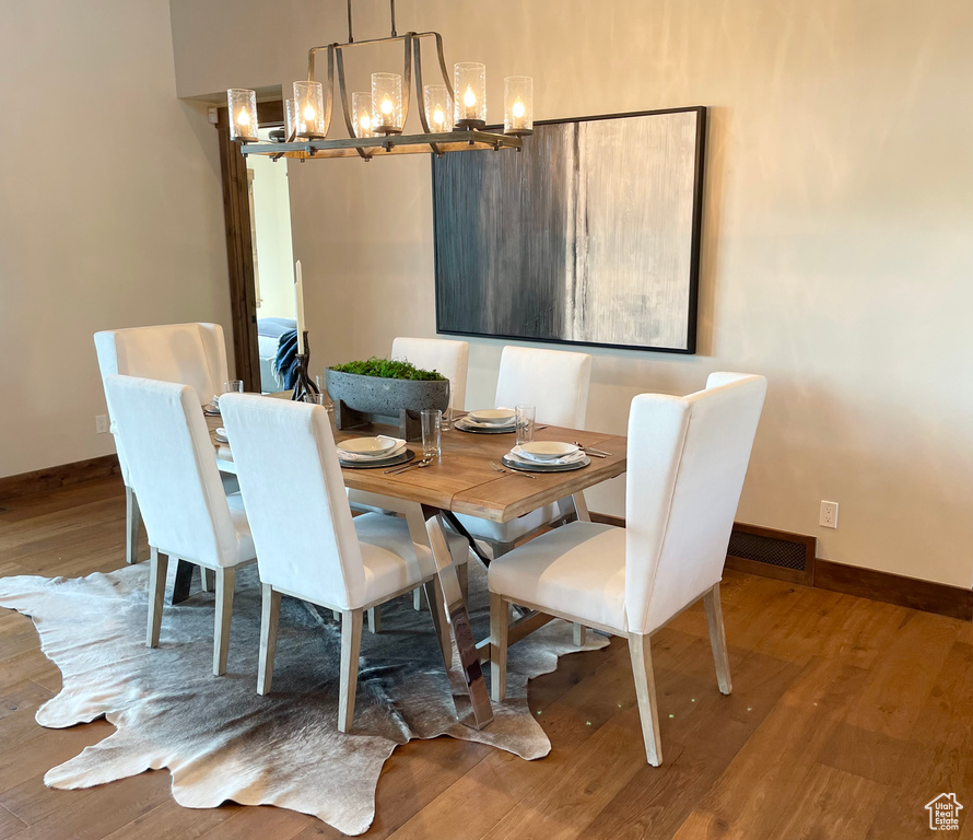 Dining space with an inviting chandelier and hardwood / wood-style floors