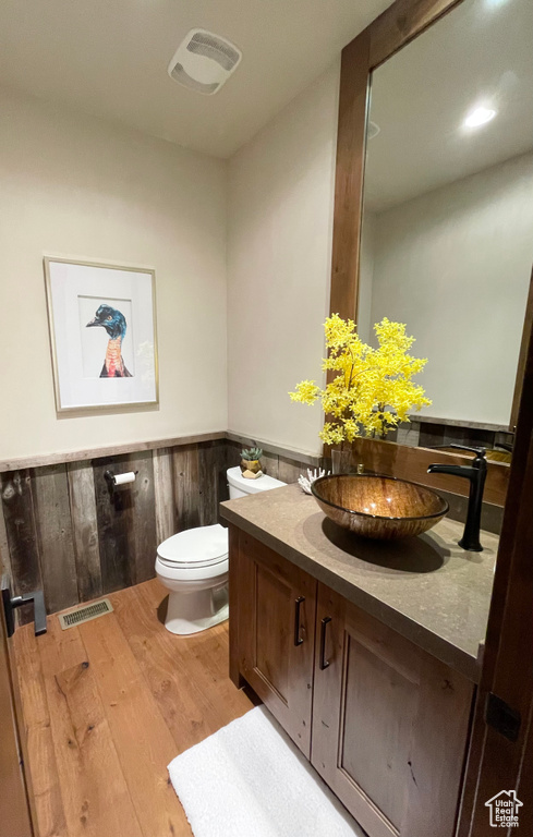 Bathroom featuring toilet, hardwood / wood-style flooring, and vanity