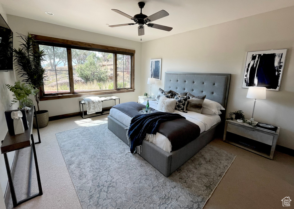 Carpeted bedroom featuring ceiling fan