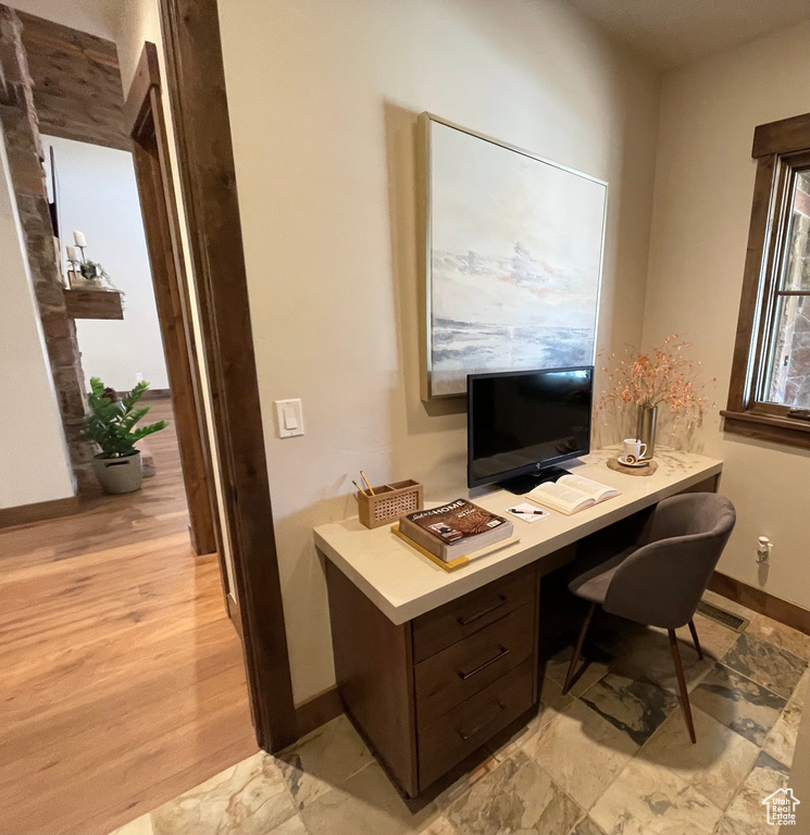 Office space with light hardwood / wood-style floors