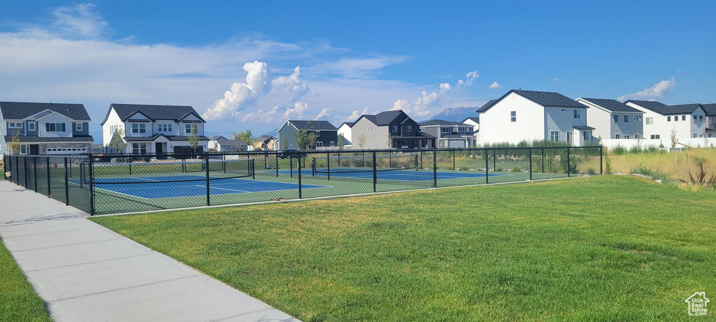 View of tennis court featuring a yard