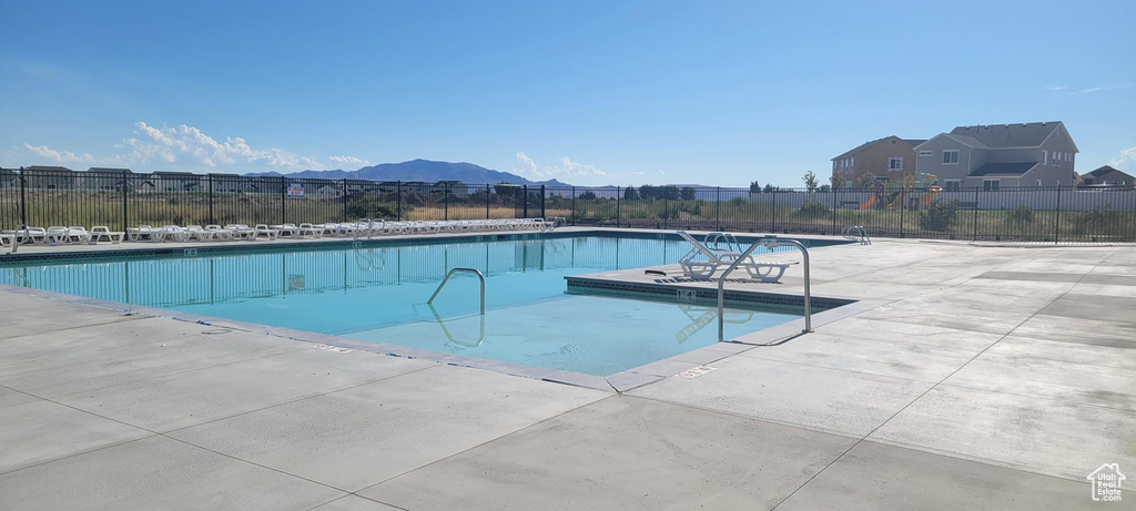 View of pool with a mountain view and a patio area