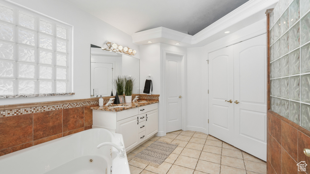 Bathroom featuring tile flooring, ornamental molding, large vanity, and tiled tub