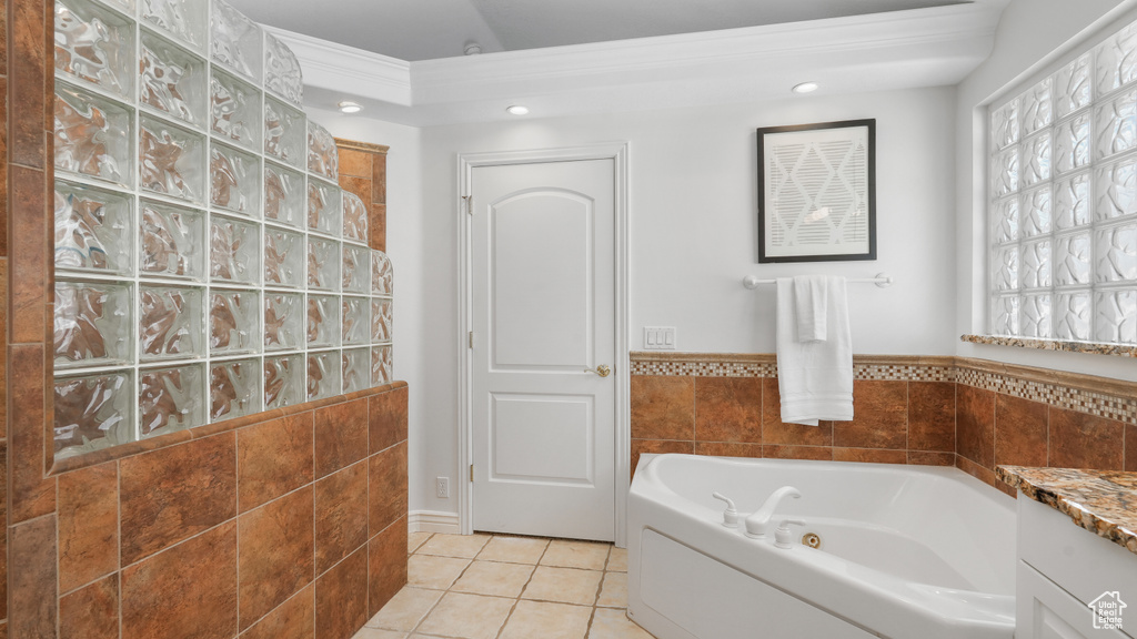 Bathroom with tile floors, ornamental molding, a washtub, and vanity