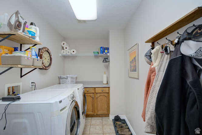 Washroom with washer and clothes dryer, cabinets, washer hookup, and light tile floors
