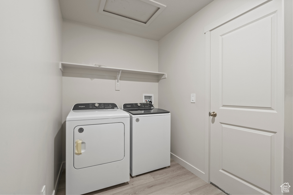 Washroom featuring light hardwood / wood-style flooring, hookup for a washing machine, and washer and dryer