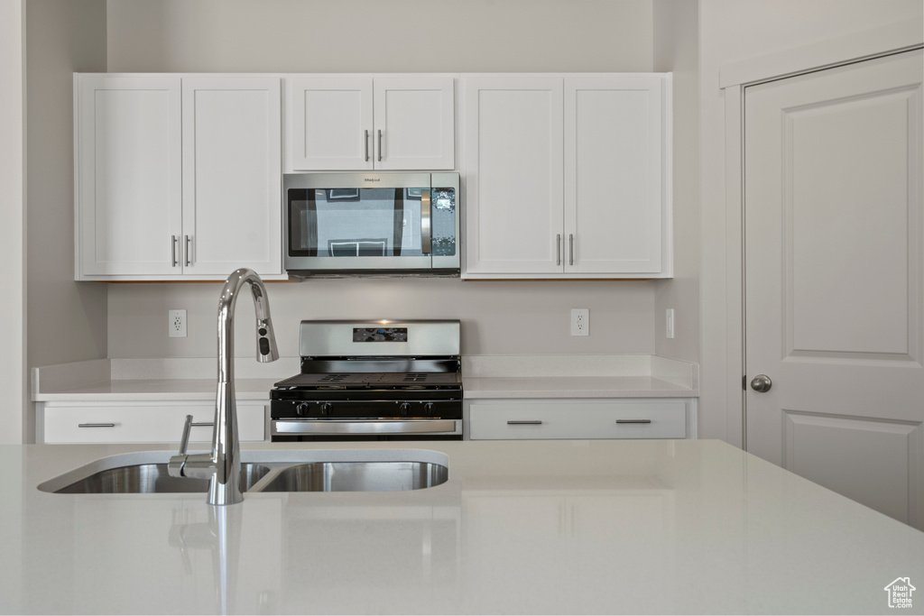Kitchen with white cabinets, sink, and appliances with stainless steel finishes