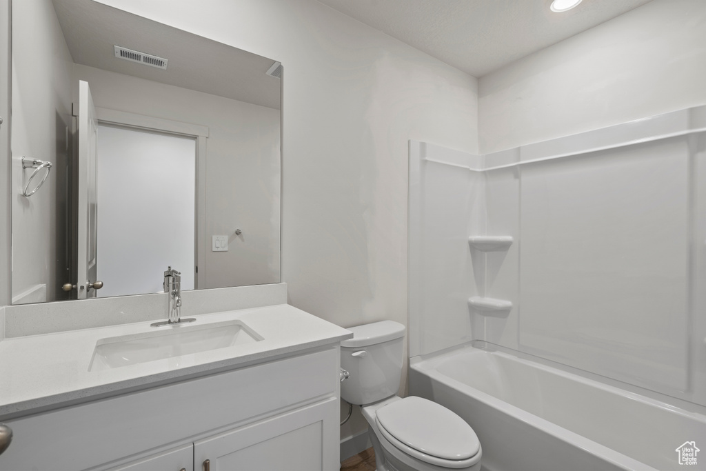Full bathroom featuring vanity, toilet, and shower / bathtub combination