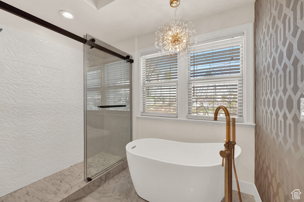 Bathroom with an inviting chandelier, tile flooring, and walk in shower