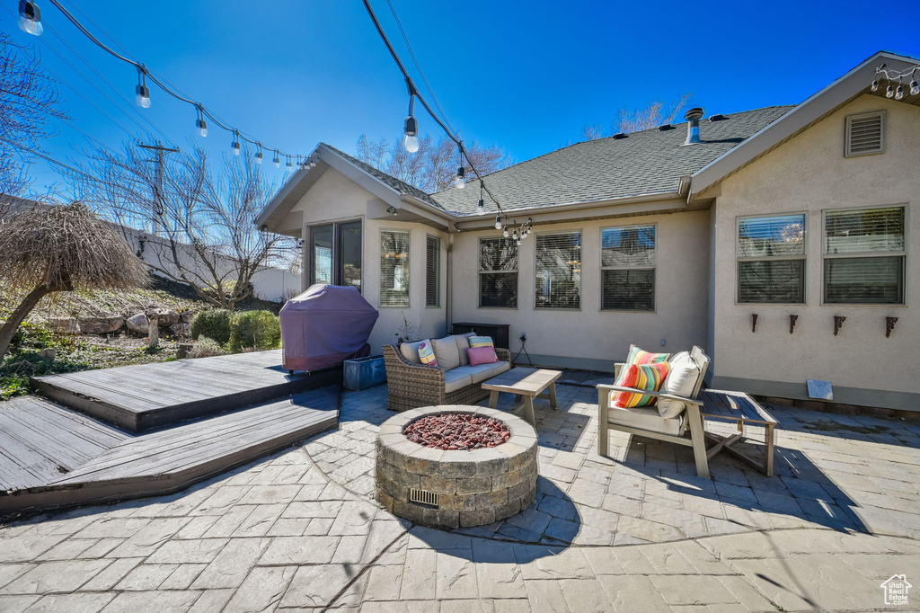 View of patio featuring an outdoor living space with a fire pit, grilling area, and a deck