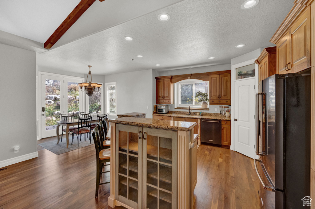 Kitchen featuring stainless steel dishwasher, pendant lighting, fridge, and dark hardwood / wood-style floors