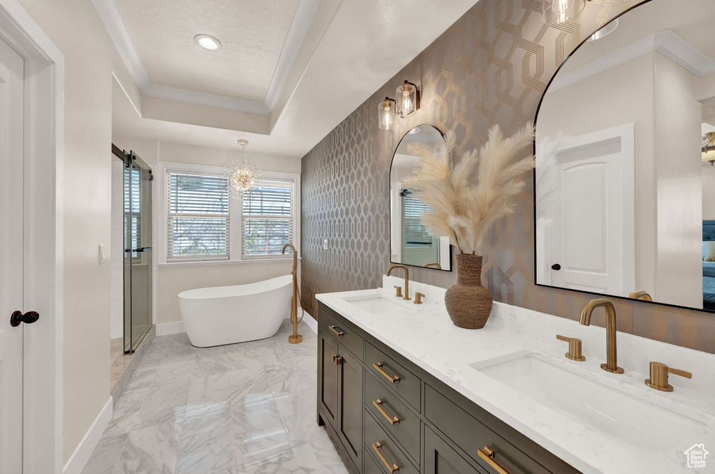 Bathroom featuring an inviting chandelier, double sink vanity, ornamental molding, and tile flooring