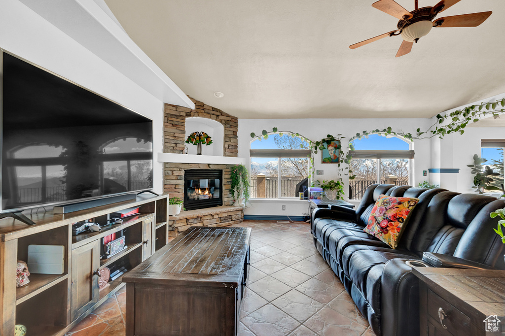 Tiled living room with a fireplace and ceiling fan