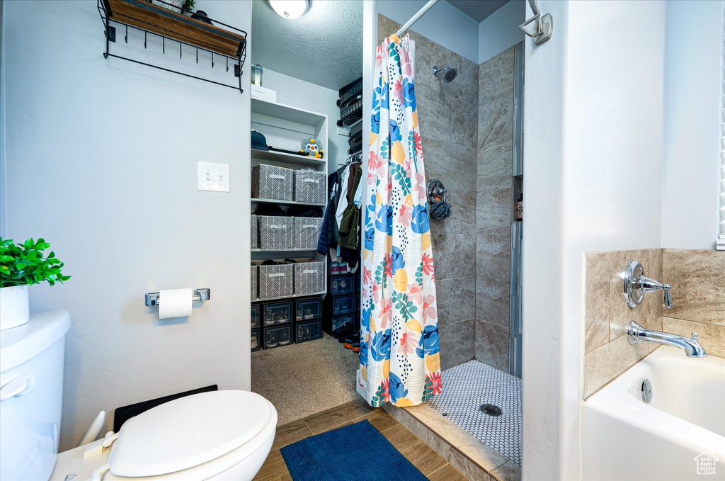 Bathroom featuring toilet and curtained shower