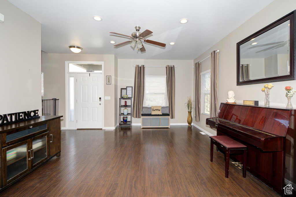 Interior space with ceiling fan and dark wood-type flooring