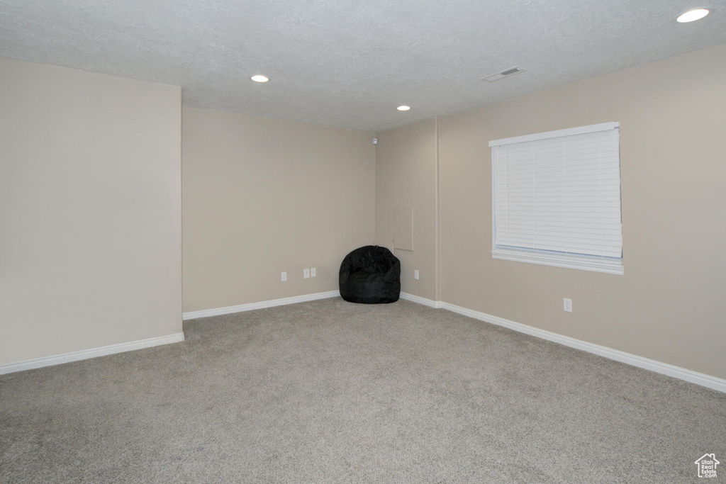 Spare room featuring a textured ceiling and carpet