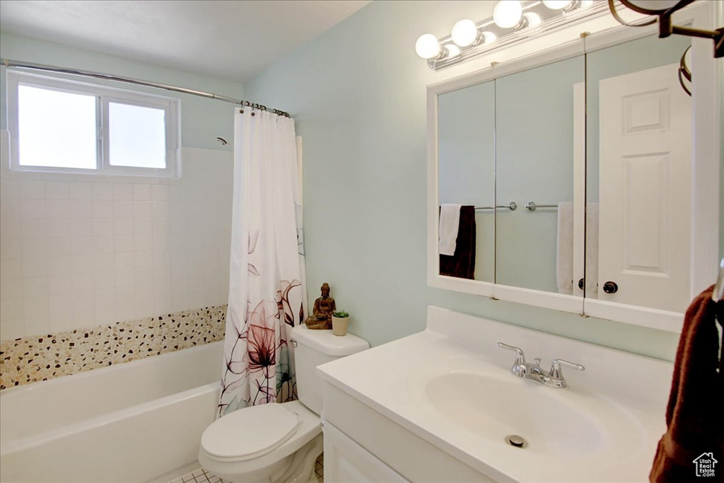 Full bathroom with shower / bath combination with curtain, vanity, and toilet