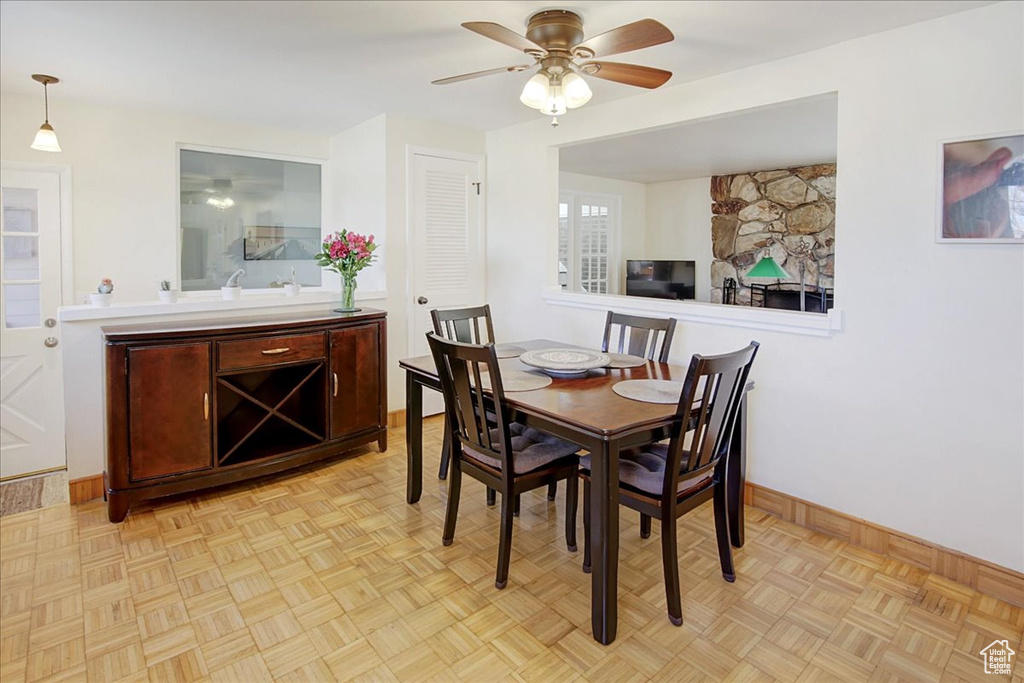 Dining area with light parquet floors and ceiling fan