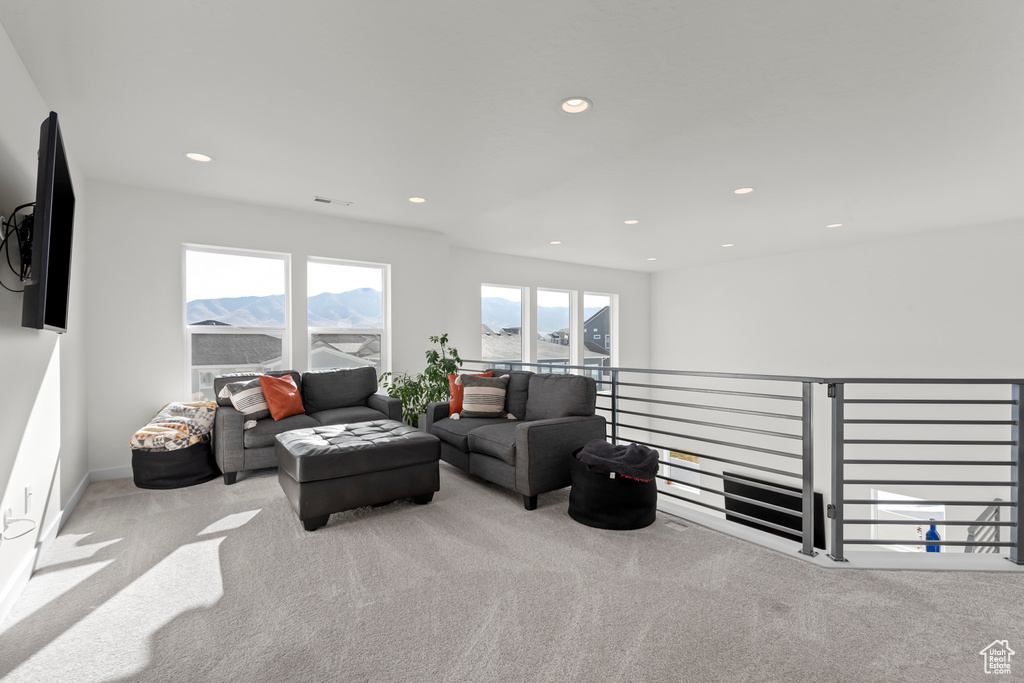Living room featuring light colored carpet and a mountain view