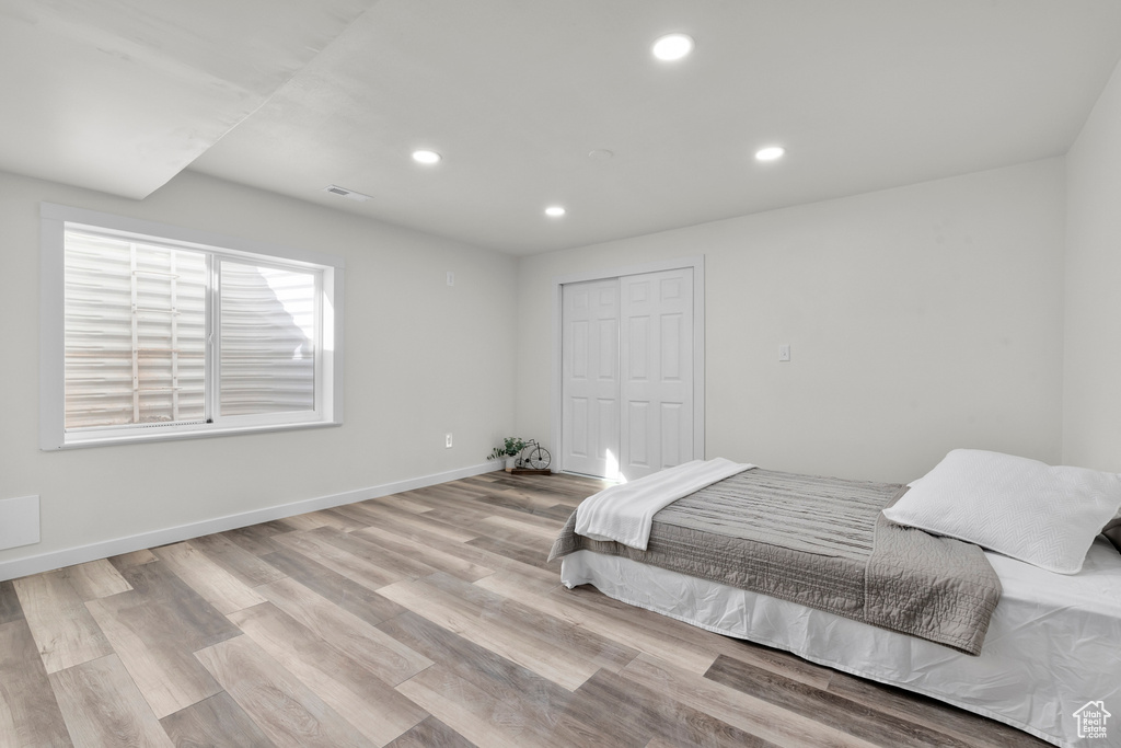 Bedroom with light wood-type flooring and a closet