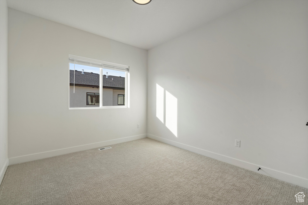 Unfurnished room featuring light carpet and a wealth of natural light